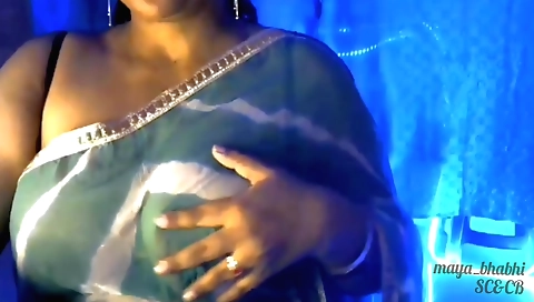 Tucks her bra under and rubs her breasts with a small hand