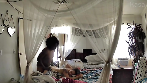 Asian woman and an african man are having a sex in the bed